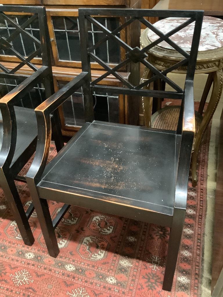 A pair of George III style ebonised elbow chairs